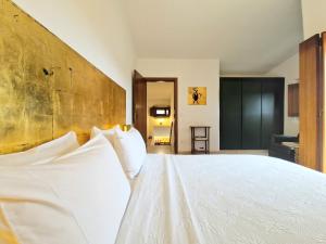 a bedroom with a large white bed with white pillows at Villa Pedra Natural Houses in Alvorge