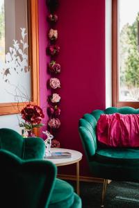 a living room with a green couch and pink wall at Design Hotel Romantick in Třeboň