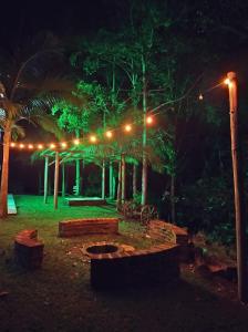 nachts ein Park mit Lichtern, Bäumen und Bänken in der Unterkunft Casa Meu Céu in Itá