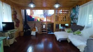 ein Wohnzimmer mit einem Sofa und einem TV in der Unterkunft Casa Meu Céu in Itá