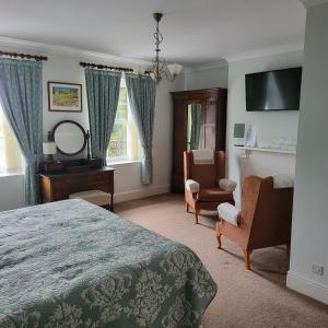 een slaapkamer met een bed, een stoel en een spiegel bij Hardwick Farm in Abergavenny