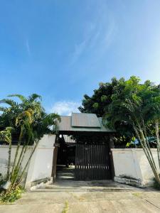 une maison avec un portail et des palmiers dans l'établissement Lungsonhouse, à Pai