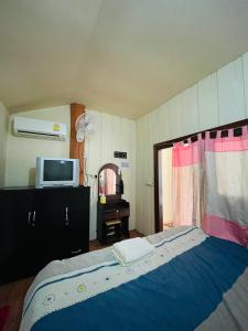 ein Schlafzimmer mit einem Bett und einem TV. in der Unterkunft Lungsonhouse in Pai