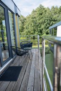 a deck with two chairs and a table at 80qm privates Hausboot in Hamburg-Mitte in Hamburg +19 photos