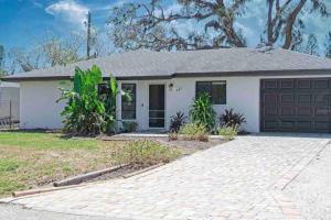 a house with a garage and a driveway at Shamrock Park, Legacy Trail and Manasota Key! in Venice