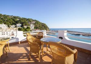 eine Terrasse mit einem Tisch, Stühlen und Meerblick in der Unterkunft Hotel Llafranch in Llafranc