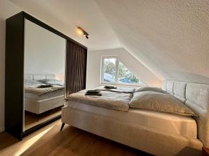 1 dormitorio con cama y espejo grande en Ferienhaus Franke am Großen Meer, en Südbrookmerland