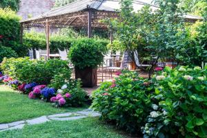 een tuin met een tuinhuisje en kleurrijke bloemen bij Hotel Franceschi in Forte dei Marmi