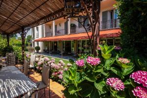 un patio con fiori rosa di fronte a un edificio di Hotel Franceschi a Forte dei Marmi