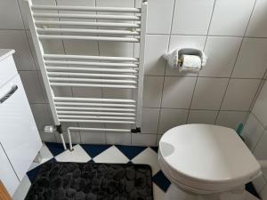 a bathroom with a white toilet and a black and white floor at Ferienhaus - a90588 in Grevesmühlen