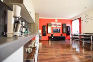 a kitchen and dining room with red walls at schöne, vollausgestattete 90m2 Wohnung mit drei Zimmern am Land 