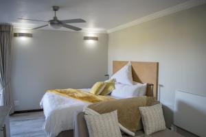Schlafzimmer mit einem Bett und einem Deckenventilator in der Unterkunft Vista Views in Herolds Bay