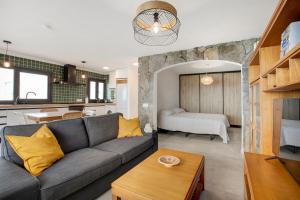 un soggiorno con divano grigio e una cucina di Apartamento Atlántico a Los Realejos
