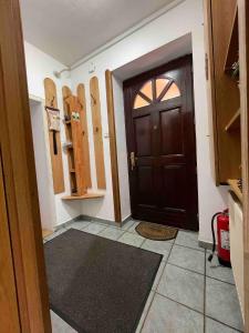 a hallway with a door and a room with wooden cabinets at Celesta Trei Brazi in Predeal