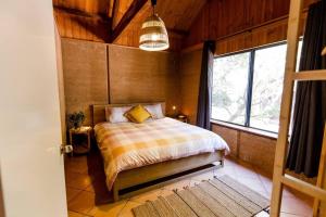 a bedroom with a bed and a large window at Beachy Sleeps! Eco Friendly Family Retreat in Prevelly