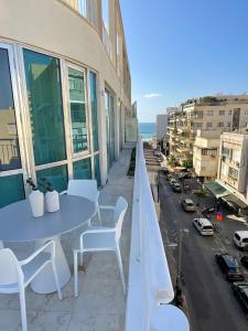 een tafel en stoelen op een balkon met uitzicht op de stad bij David Frishman Residence - Sea view penthouse in Tel Aviv