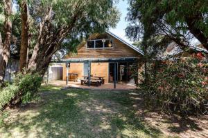 a house with a picnic table in front of it at Beachy Sleeps! Eco Friendly Family Retreat in Prevelly