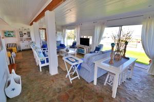 uma sala de estar com um sofá e uma mesa em Kykmar Beach House em Stilbaai