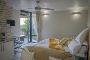 a living room with a couch and a ceiling fan at Vista Views in Herolds Bay