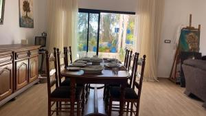 a dining room with a table with chairs and a window at Casa Zitouna - Guest House - Kef, Tunisia in Sicca Veneria