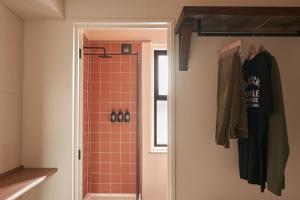 uma casa de banho com um chuveiro com azulejos laranja em Deus Lodge of Heavy Leisure em Bournemouth