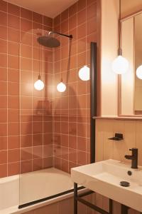 een badkamer met een douche, een wastafel en verlichting bij Deus Lodge of Heavy Leisure in Bournemouth