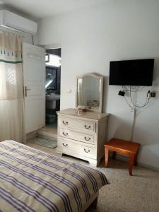 1 dormitorio con 1 cama y vestidor con espejo en Casa Zitouna - Guest House - Kef, Tunisia en El Kef