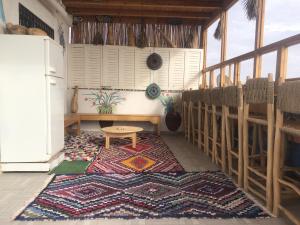 een kamer met een tafel en een tapijt op een vloer bij Hostel blue house Taghazout in Taghazout