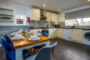 a kitchen with a wooden table and blue chairs at Spacious House With Driveway Parking in Southampton