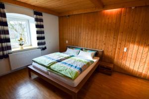 a bedroom with a bed with a wooden wall at schöne, vollausgestattete 90m2 Wohnung mit drei Zimmern am Land 
