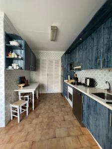 a kitchen with blue cabinets and a sink and a table at Vivienda La Puerta del Perdon in Constantina