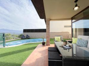 un patio con sofá y piscina en CASA VISTA SIERRA, en Jaraíz de la Vera