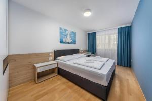 a bedroom with a large bed with blue curtains at Garden Palace Resort in Umag