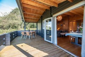 a deck with a table and a dining room at The Cabin, Parham in Woodbridge