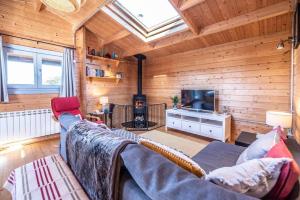 ein Wohnzimmer mit einem Sofa und einem TV in der Unterkunft The Cabin, Parham in Woodbridge
