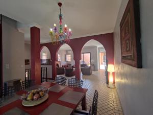 een eetkamer met een tafel en een kroonluchter bij Chambre Secret Room, Riad 3 Couple only au village naturiste in Cap d'Agde