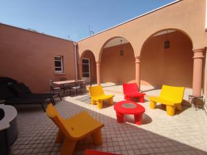 een groep kleurrijke stoelen en tafels op een patio bij Chambre Secret Room, Riad 3 Couple only au village naturiste in Cap d'Agde