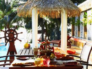 een tafel met eten en een rieten parasol op een patio bij Vartika Resovilla Kuiburi Beach Resort and Villas in Kui Buri