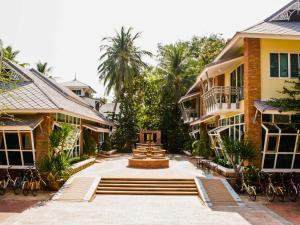 a courtyard with a fountain in the middle of two buildings at Vartika Resovilla Kuiburi Beach Resort and Villas in Kui Buri