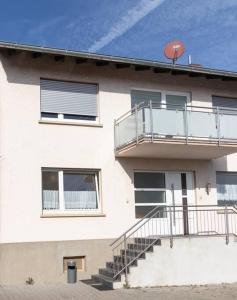 a building with a balcony and stairs on it at Monteurwohnung im schönen Essenheim bei Mainz in Essenheim