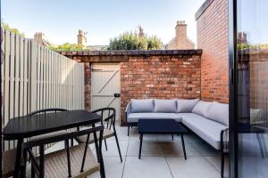 a patio with a couch and a table on a balcony at *NEW* Little Pyecroft House, Chester in Chester