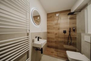 a bathroom with a sink and a toilet and a mirror at Koblenz Suites - Design Apartment Koblenz City in Koblenz