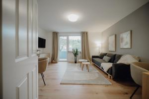 コブレンツにあるCoblenz Suites - Design Apartment Cityのソファとテーブルのあるリビングルーム