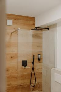 FR02 - Design Apartment Koblenz City - 1 Bedroom في كوبلنز: دش في حمام بجدار خشبي