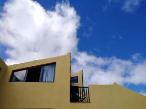 un edificio amarillo con un cielo en el fondo en Varandas Miramar en Angra do Heroísmo