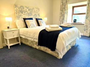 una camera da letto con un letto e due asciugamani di Booth House a Elslack