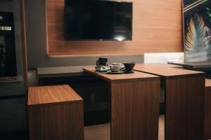 Loft com sacada, lareira e garagem no Parque Una的电视和/或娱乐中心
