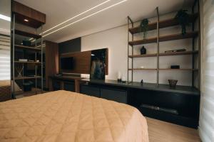 Loft com sacada, lareira e garagem no Parque Una的电视和/或娱乐中心