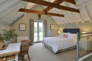 Schlafzimmer mit einem Bett, einem Schreibtisch und einem Fenster in der Unterkunft Lodge Farm in Freston