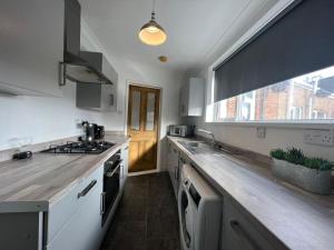 uma cozinha com um lavatório e um fogão forno superior em Alexander Apartments West Harton em South Shields